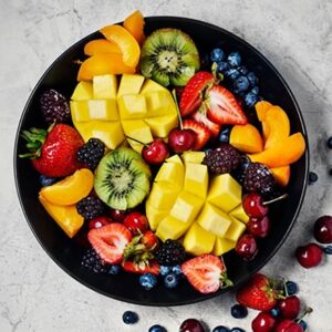 Fresh fruit Variety of fresh fruit in a bowl on stone background